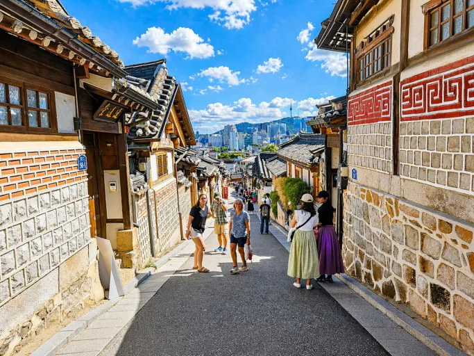 Traditional hanok houses and visitors walking through Bukchon Hanok Village in Seoul